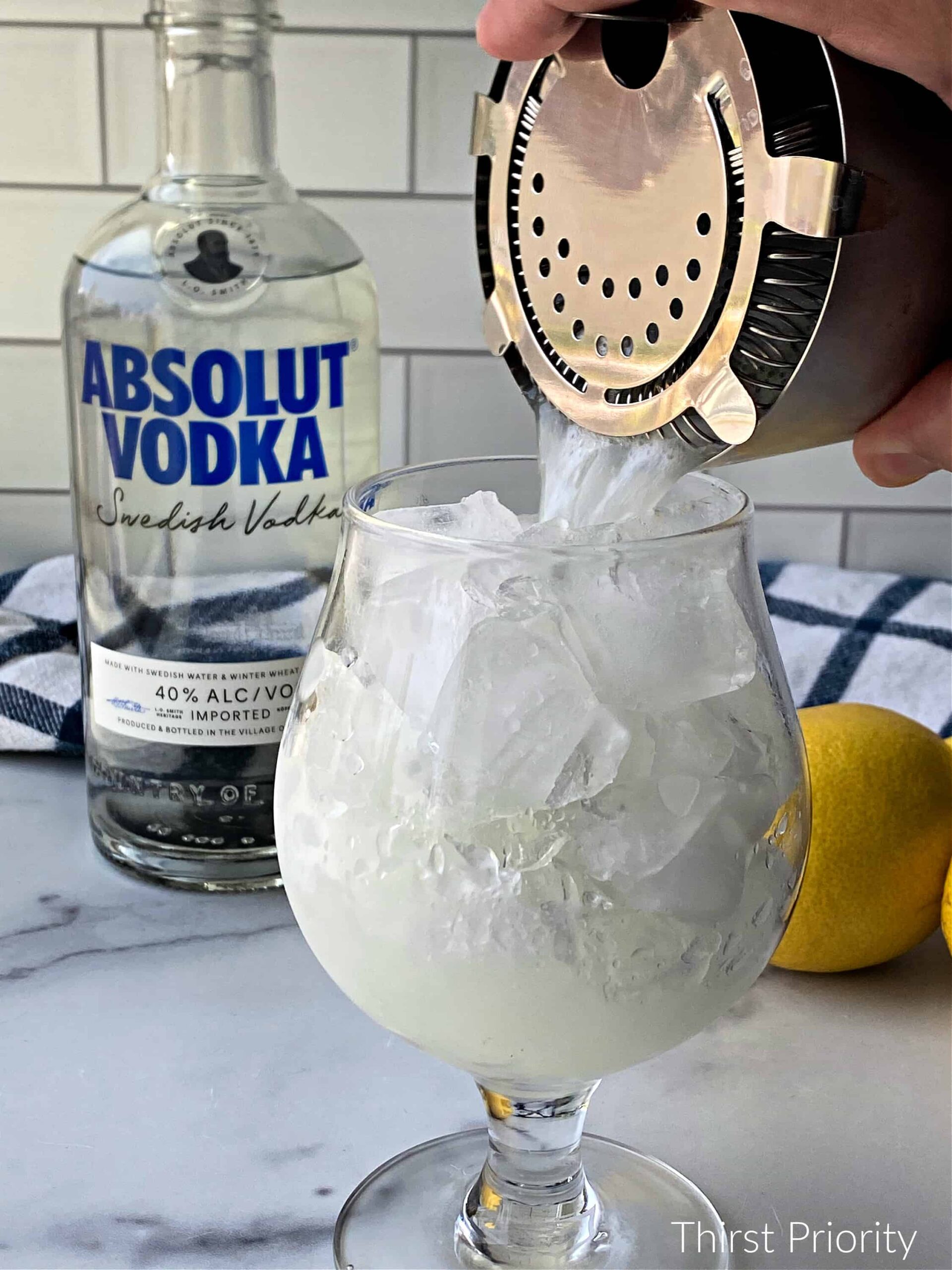 pour homemade vodka sour into cocktail glass